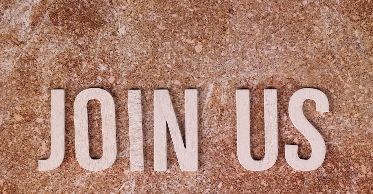 Flat lay of 'Join Us' text on a rustic stone background, inviting participation.